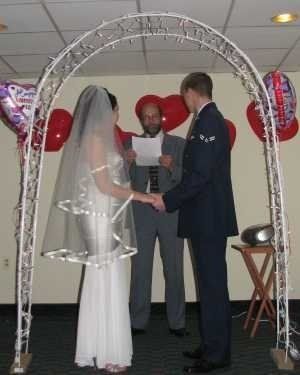 A bride and groom are holding hands during their wedding ceremony