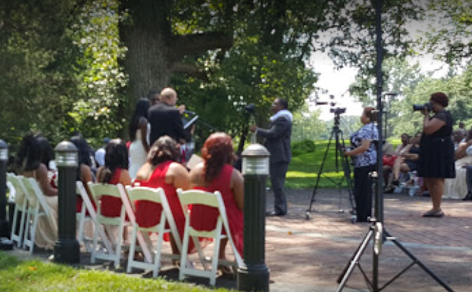 A group of people are sitting in chairs in a park.