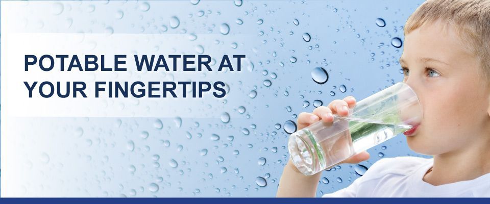 A young boy is drinking water from a glass.