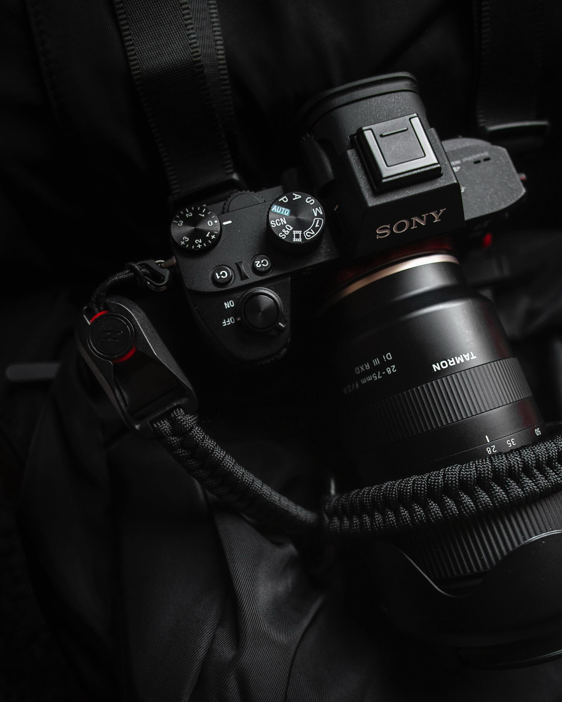 Black Sony camera with lens and braided strap.