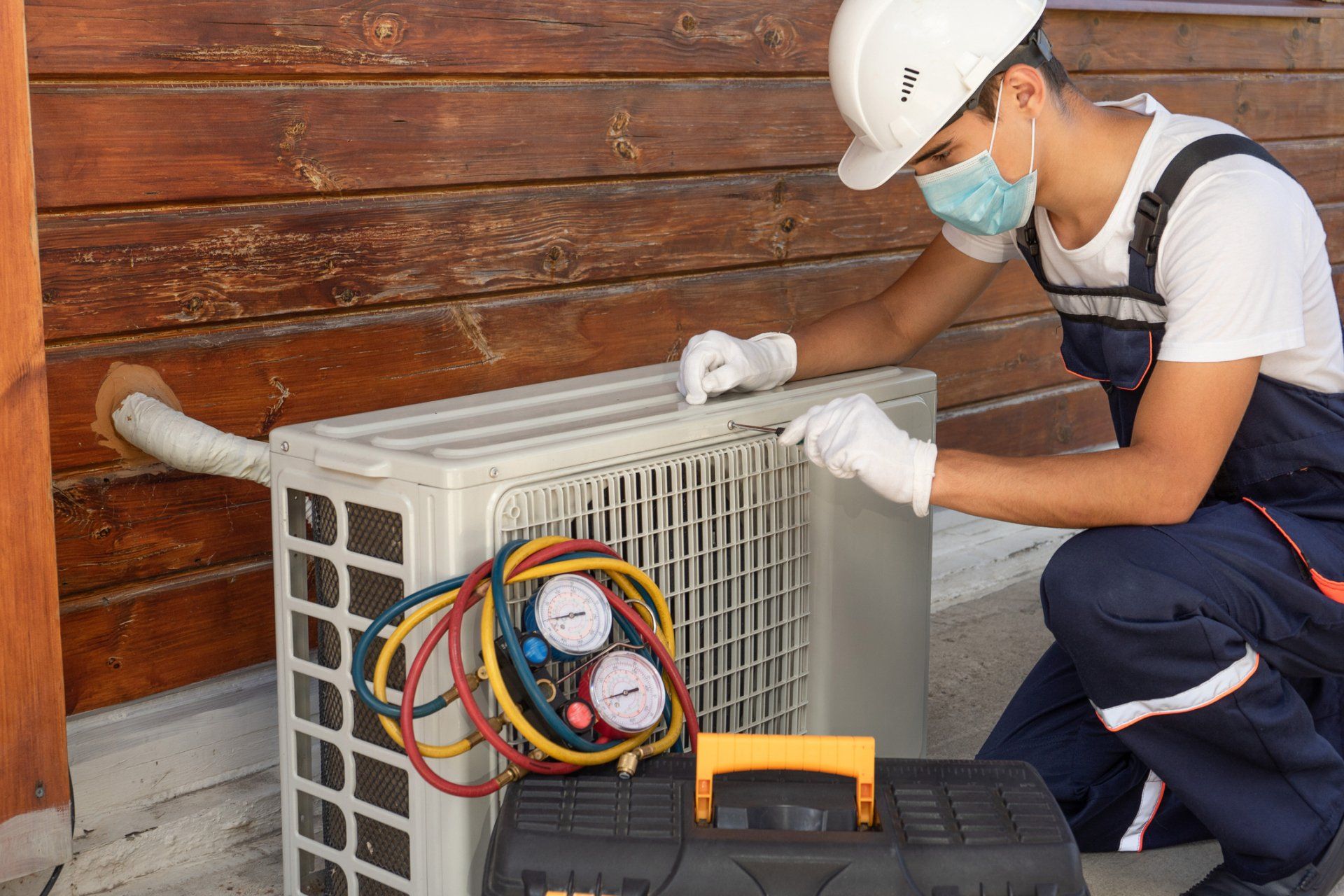 Contractor Repairing Air Conditioner — Buhler, KS — Reimer Refrigeration Contractor Repairing Air Conditioner — Buhler, KS — Reimer Refrigeration