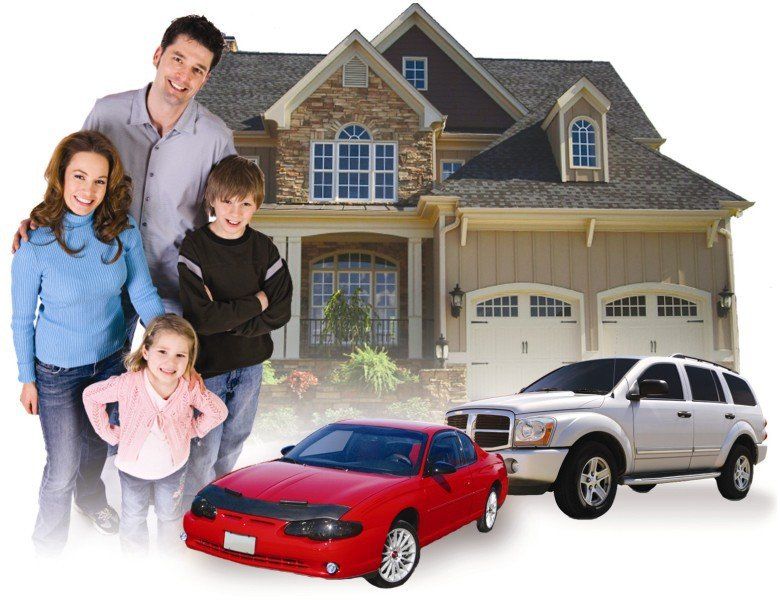 A family stands in front of their suburban home, with a red coupe and a white SUV parked in the driveway.