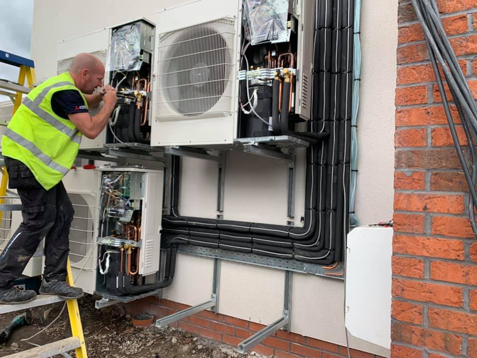 Air Conditioning Repair, repairman on the wall fixing air conditioning system