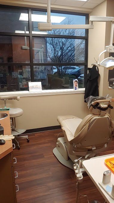Dental exam room with chair by large window and city view.