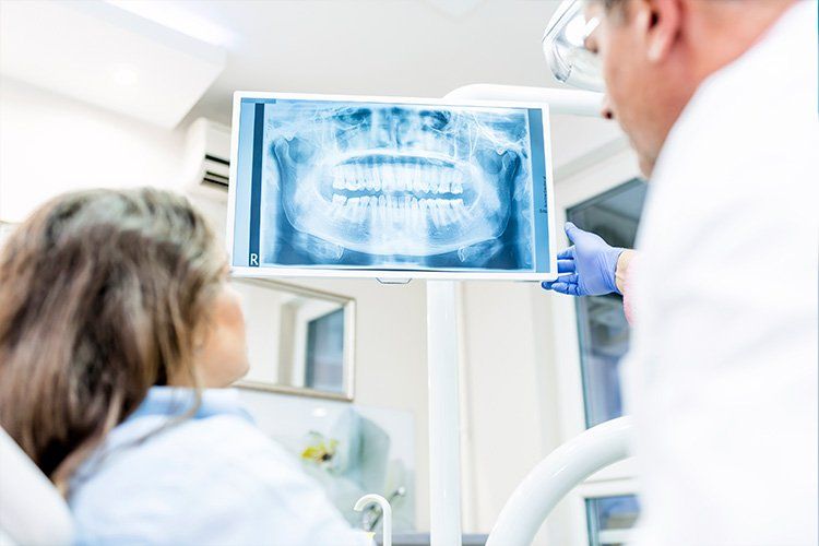 Dentist showing a patient an X-ray in a bright dental clinic