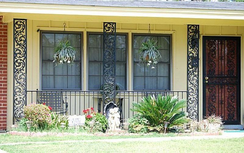 a house with a porch and flowers in front of it