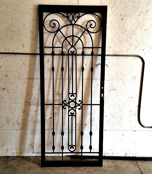 a wrought iron gate is against a white wall