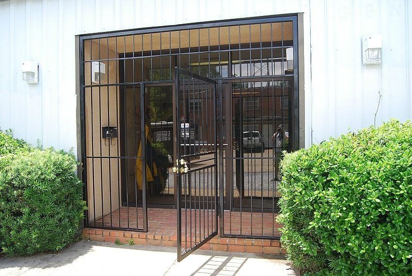 a building with a fence around it and a door that is open