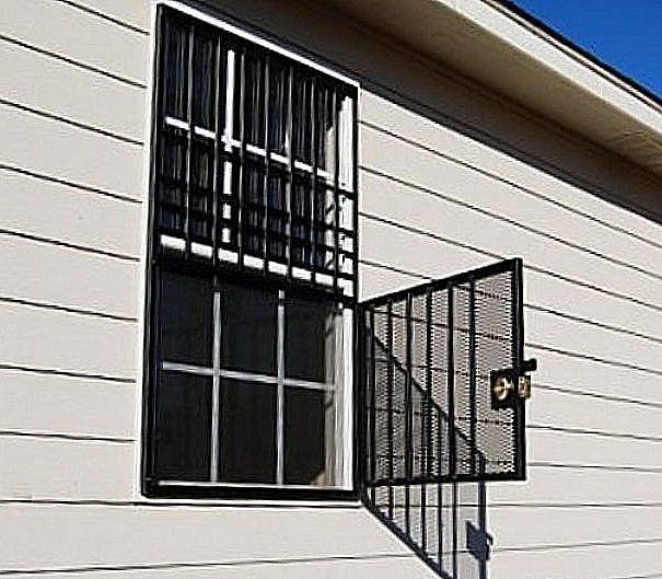 a white house with a window with bars on it