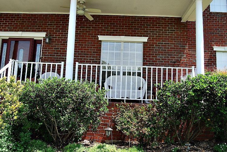 a brick house with a white table and chairs on the porch .