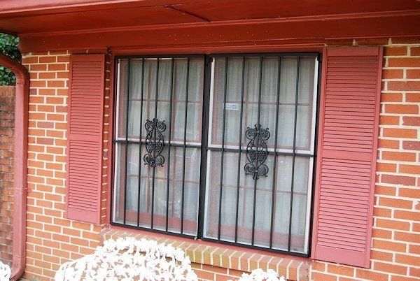 a brick house with a window with bars on it