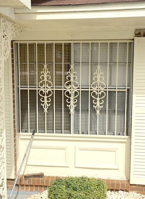 a white window with a wrought iron grill on it