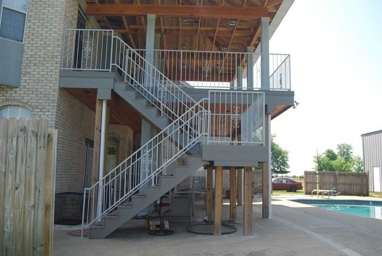 a set of stairs leading up to a balcony overlooking a pool