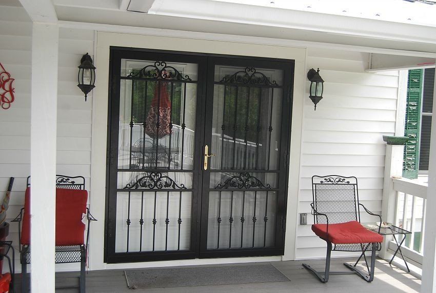 a white house with a black door and a red chair