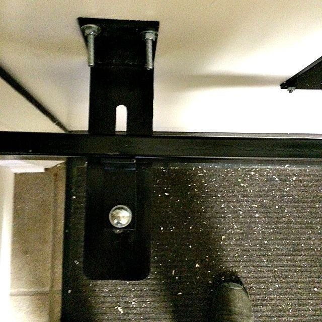 a black metal bracket with two screws attached to it