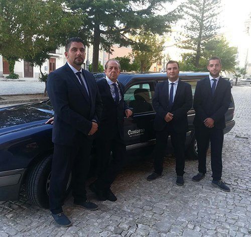 personale dell'agenzia fuebre davanti ad un carro funebre