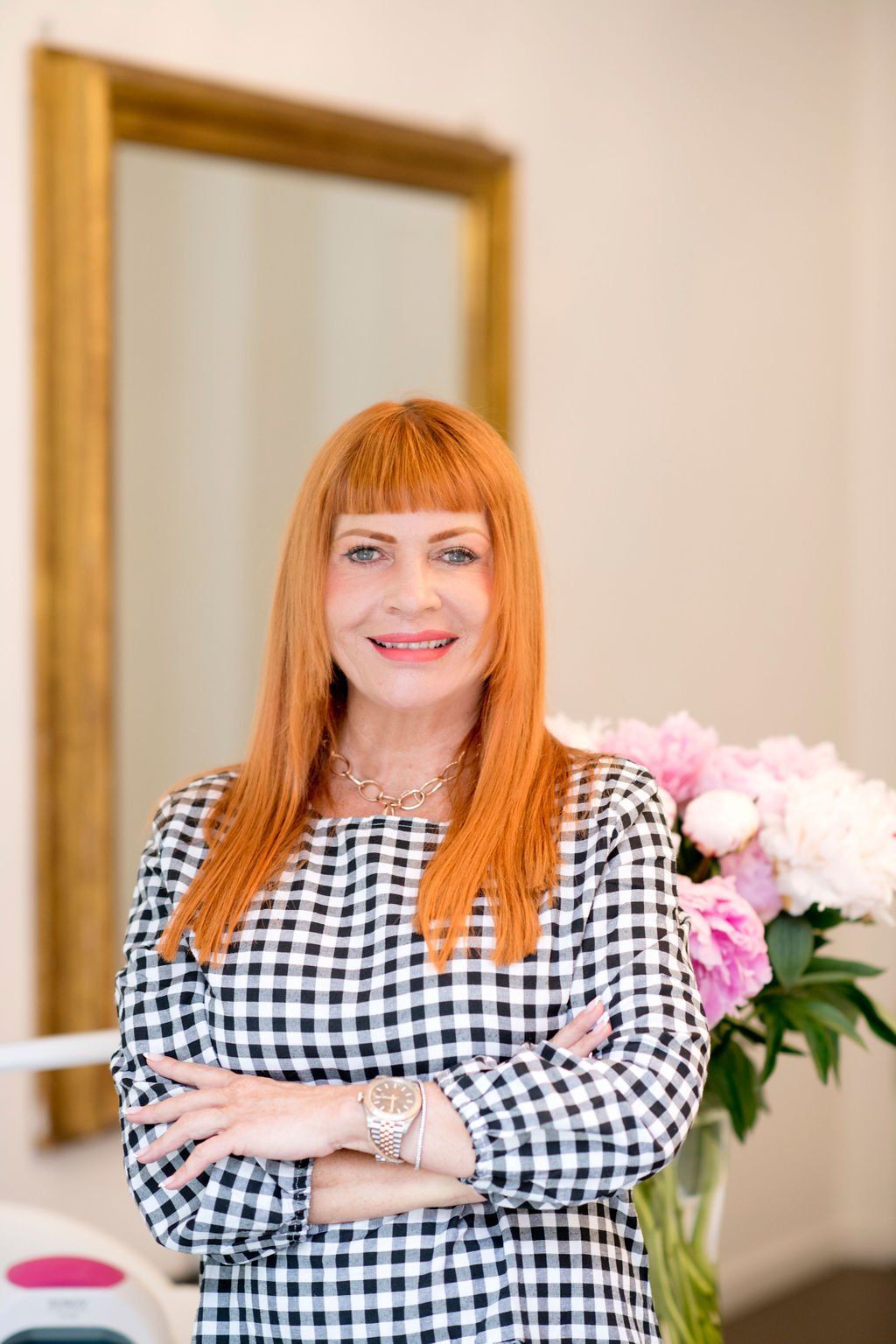 Iris Wolter, die in einem hellen Raum mit verschränkten Armen lächelt.