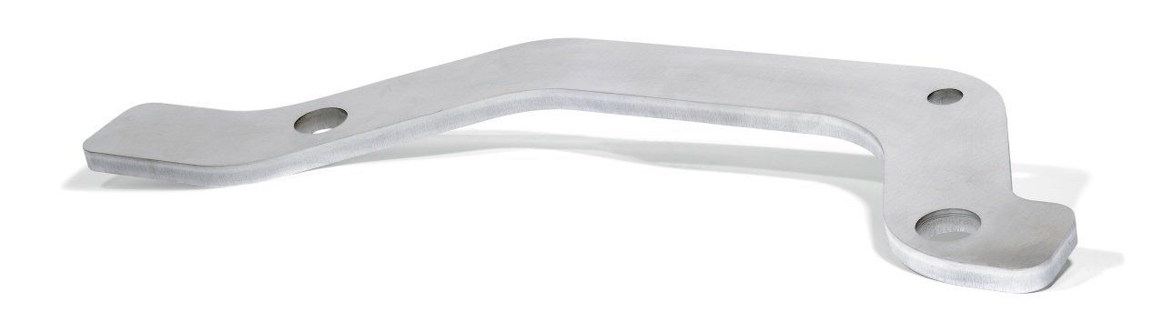 A curved, silver metal component with a few holes. It appears to be a lever or bracket, resting on a white surface.