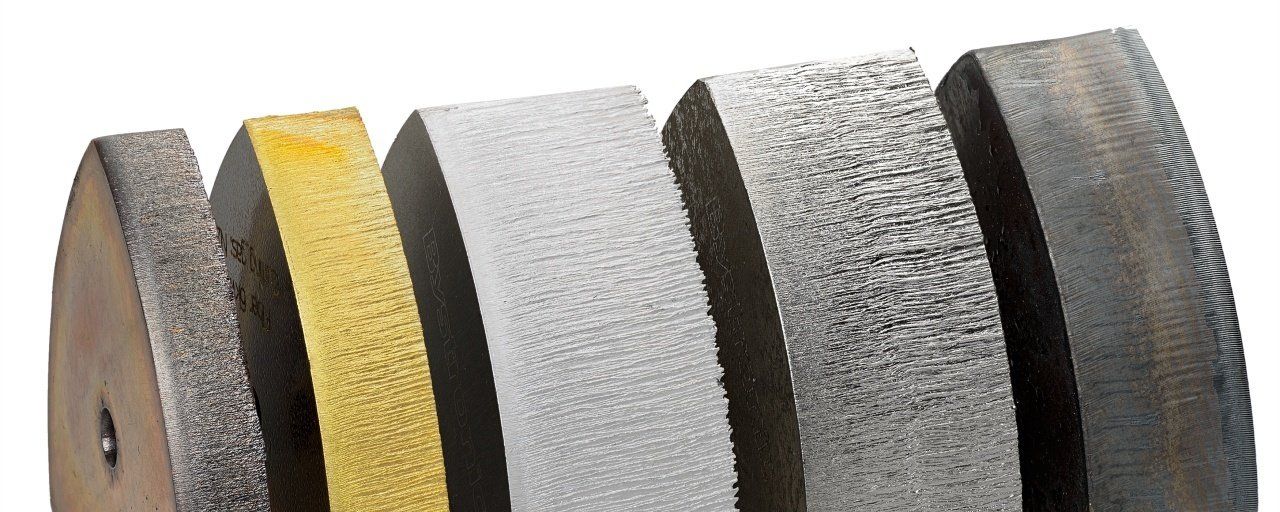 Close-up of several different abrasive grinding wheels in various textures and colors.