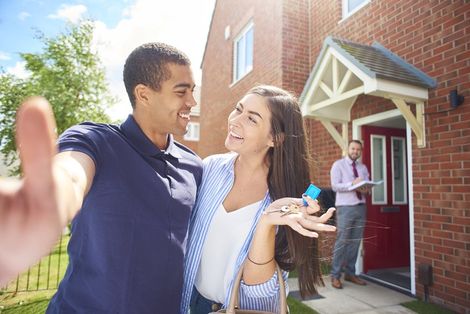 A couple takes a selfie outside their new house