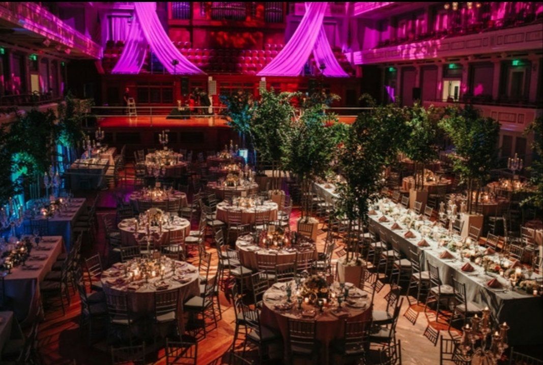 a large room filled with tables and chairs and trees