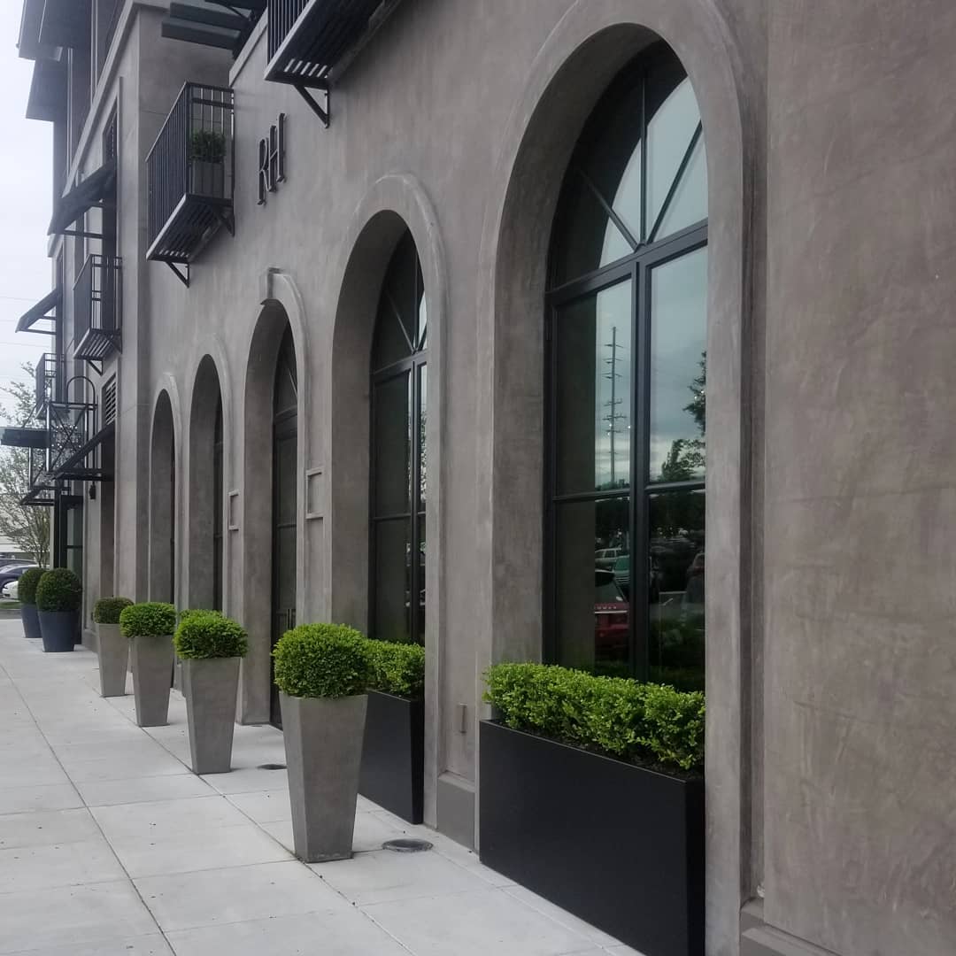 a building with a lot of windows and planters on the sidewalk