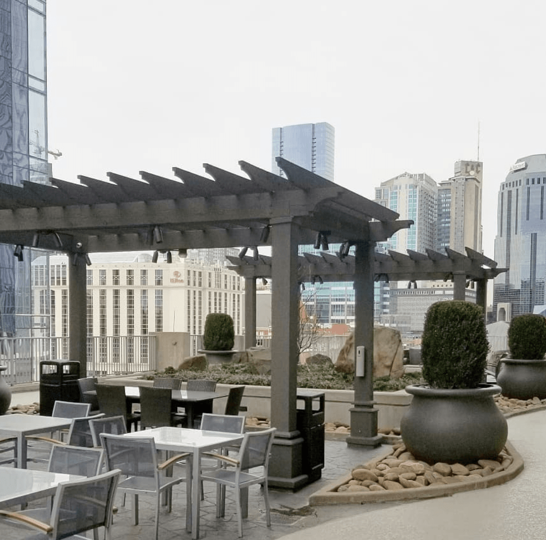 a patio with tables and chairs under a pergola