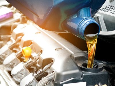 Auto Oil Changes — Pouring Oil Into The Car Engine in Kennett Square, PA Auto Oil Changes — Pouring Oil Into The Car Engine in Kennett Square, PA