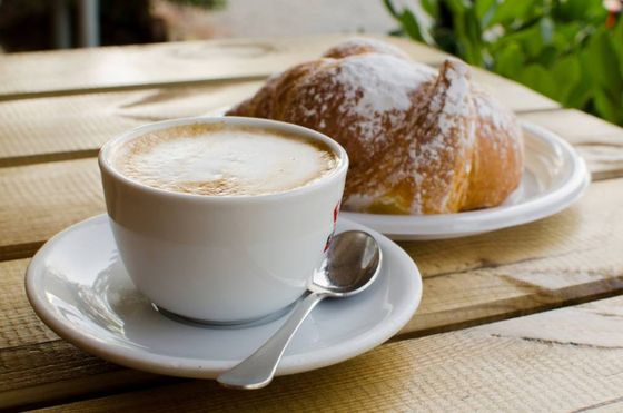 Cappuccino e brioche sul tavolo