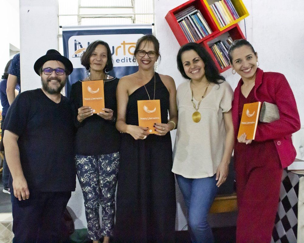 Cida Oliveira e suas primas segurando exemplares da antologia ao lado dos editores