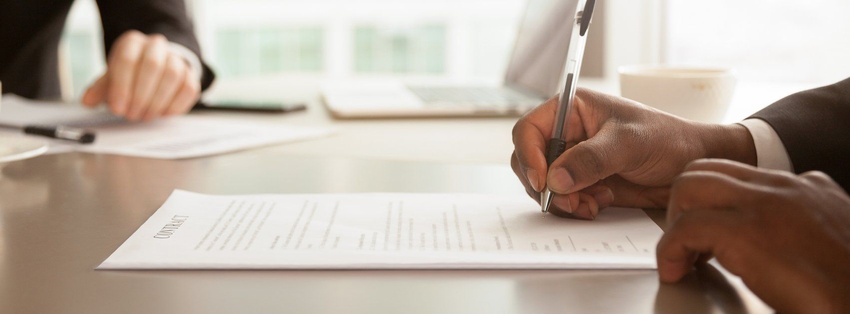 Het Mediators Collectief werkt alleen met MfN-registermediators: 085-1307476 afrikaanse zakenman zitten aan het bureau met pen ondertekent (vaststellings)overeenkomst