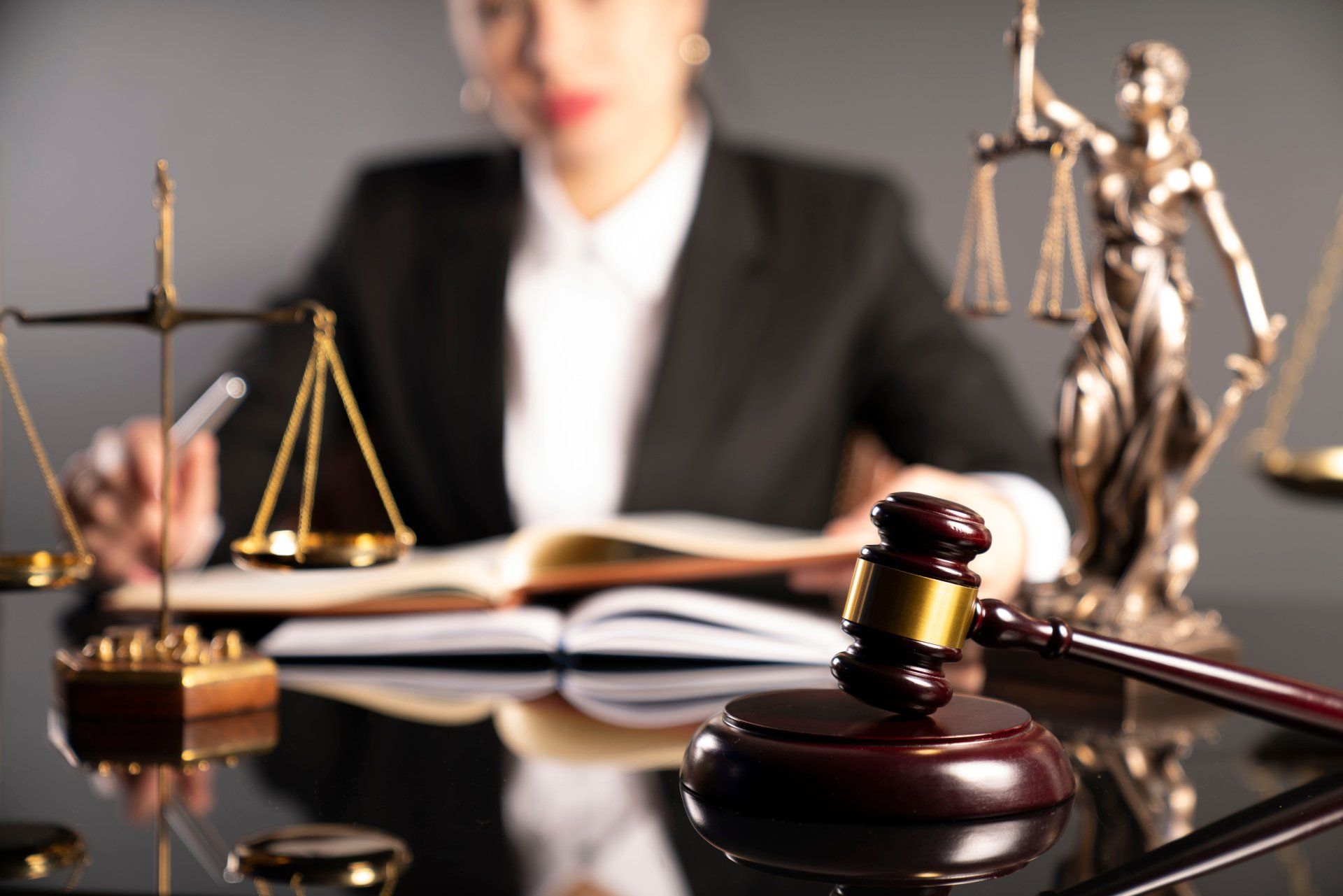 Een lange en kostbare procedure bij de rechter of in mediation er samen uitkomen? vrouwelijke advocaat achter haar bureau met weegschaal en hamer