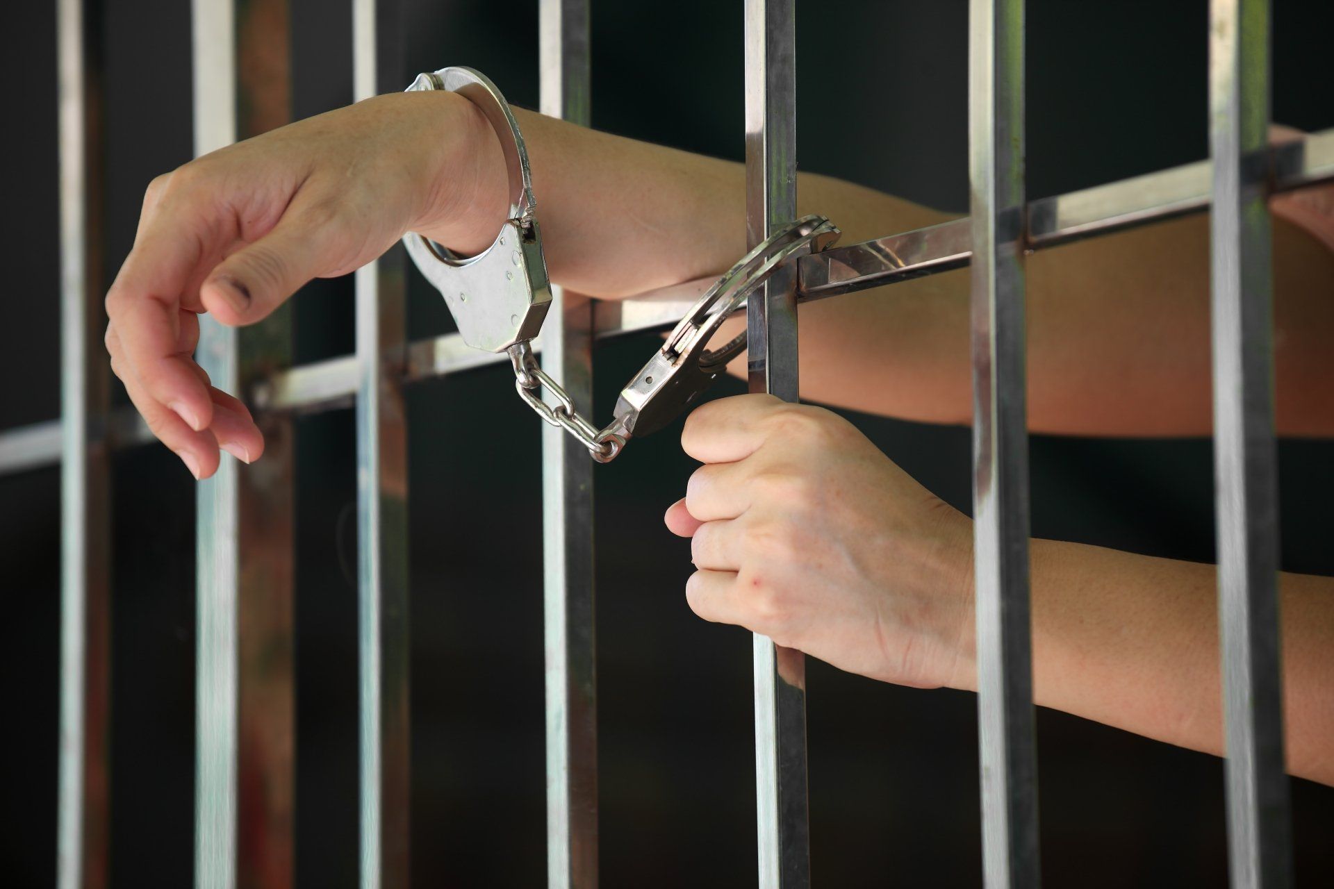 Het geloof in strenger straffen is hardnekkig hand met handboeien van gevangene achter gevangenis tralies