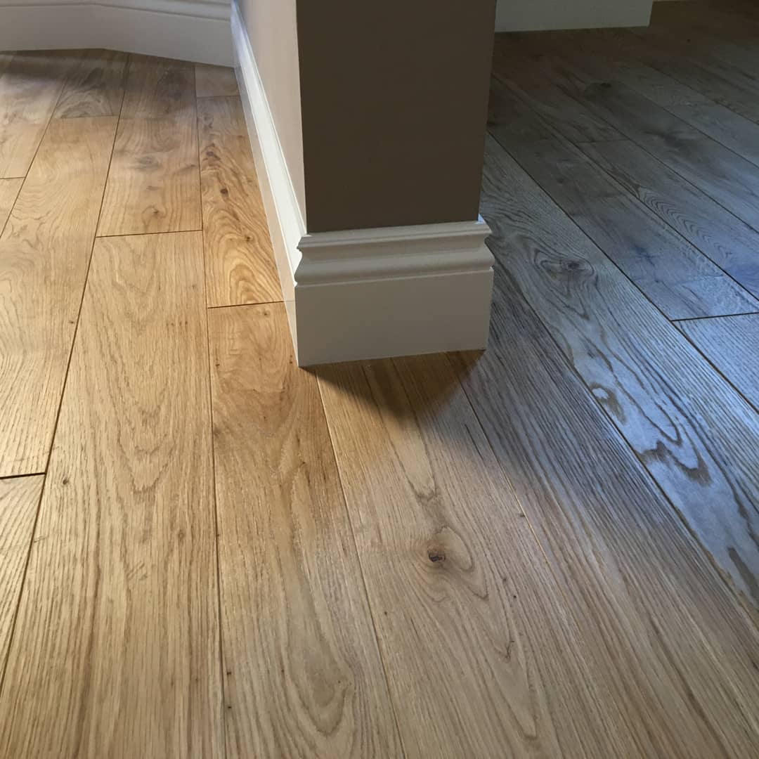 pavimento in legno con battiscopa bianco