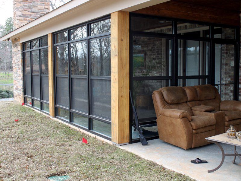 A screened in porch with a couch and chairs