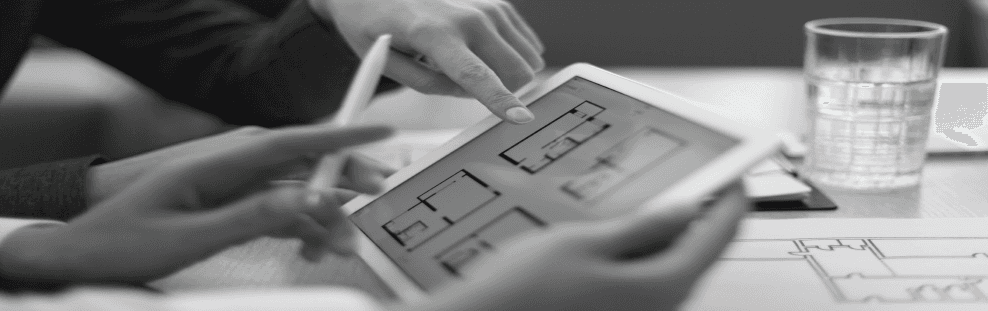 Ein Schwarzweißfoto einer Person, die einen Tablet-Computer benutzt.