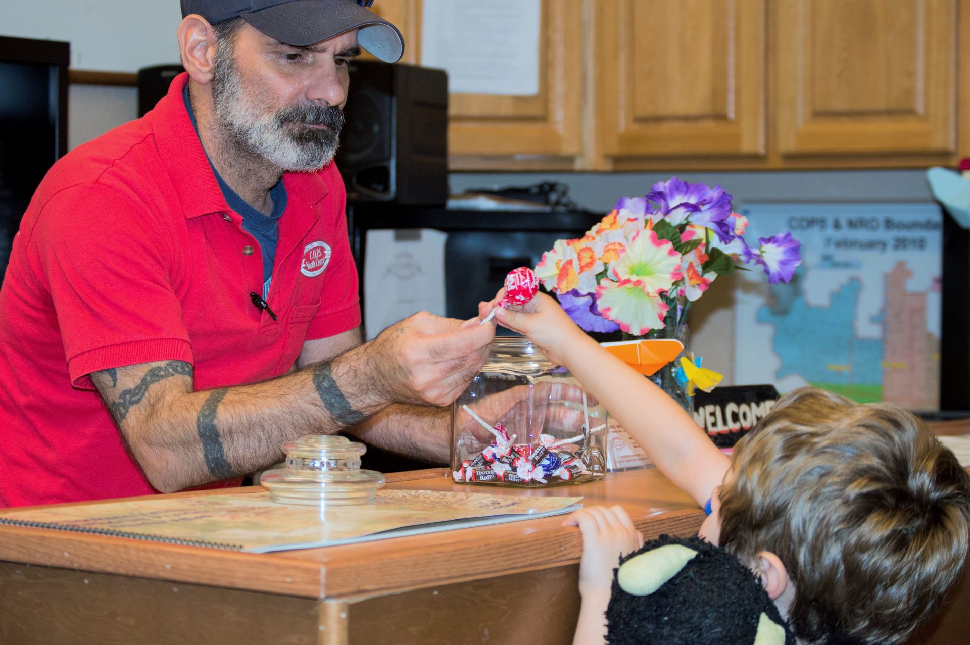 Man handing a young boy a lollipop