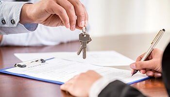 Man Signing the Land Paper's and Man Holding the Key — Practice Bankruptcies in Youngstown, OH