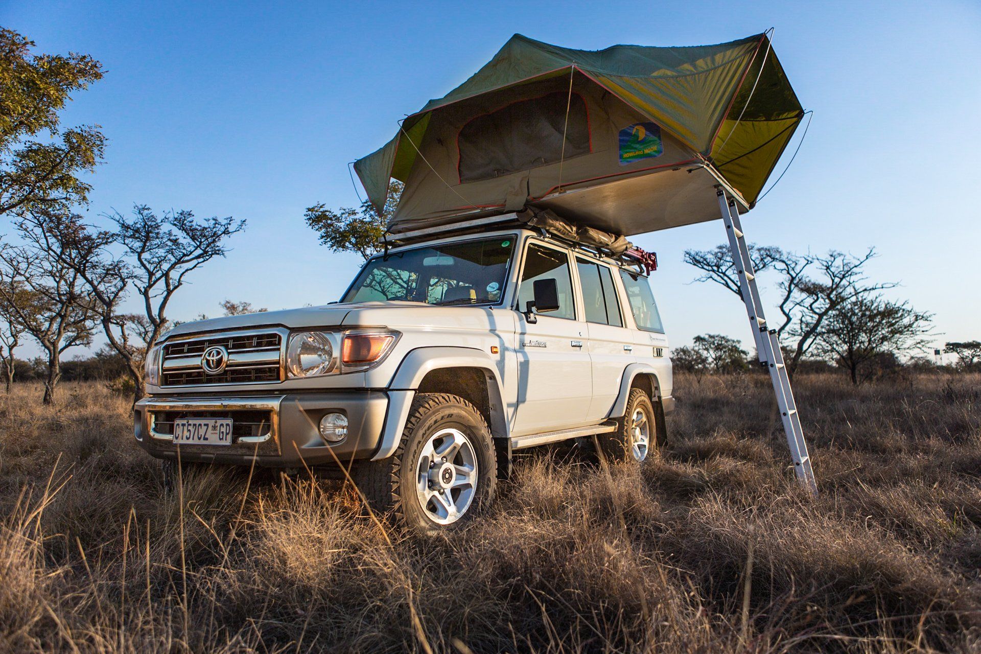 Toyota safari 4x4 vehicle in the african bush with a tent installed on it's roof