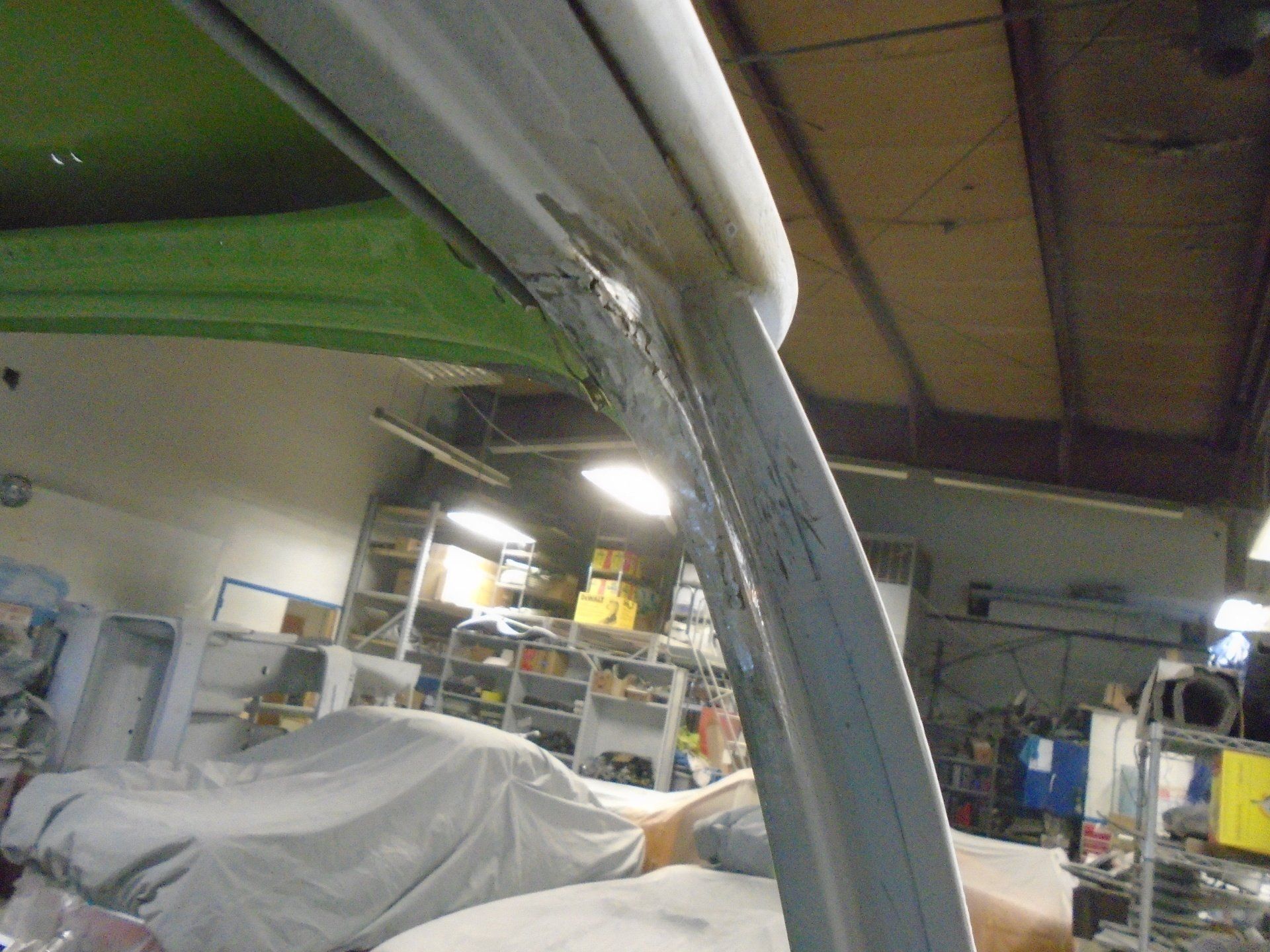 Interior car frame, damaged with filler. Green interior, workshop setting.