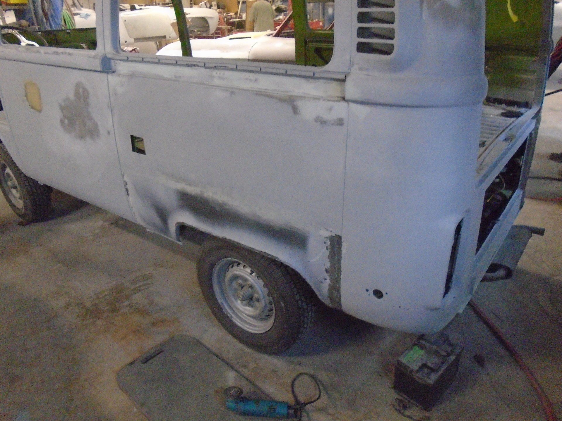 Partially restored grey Volkswagen van in a workshop.