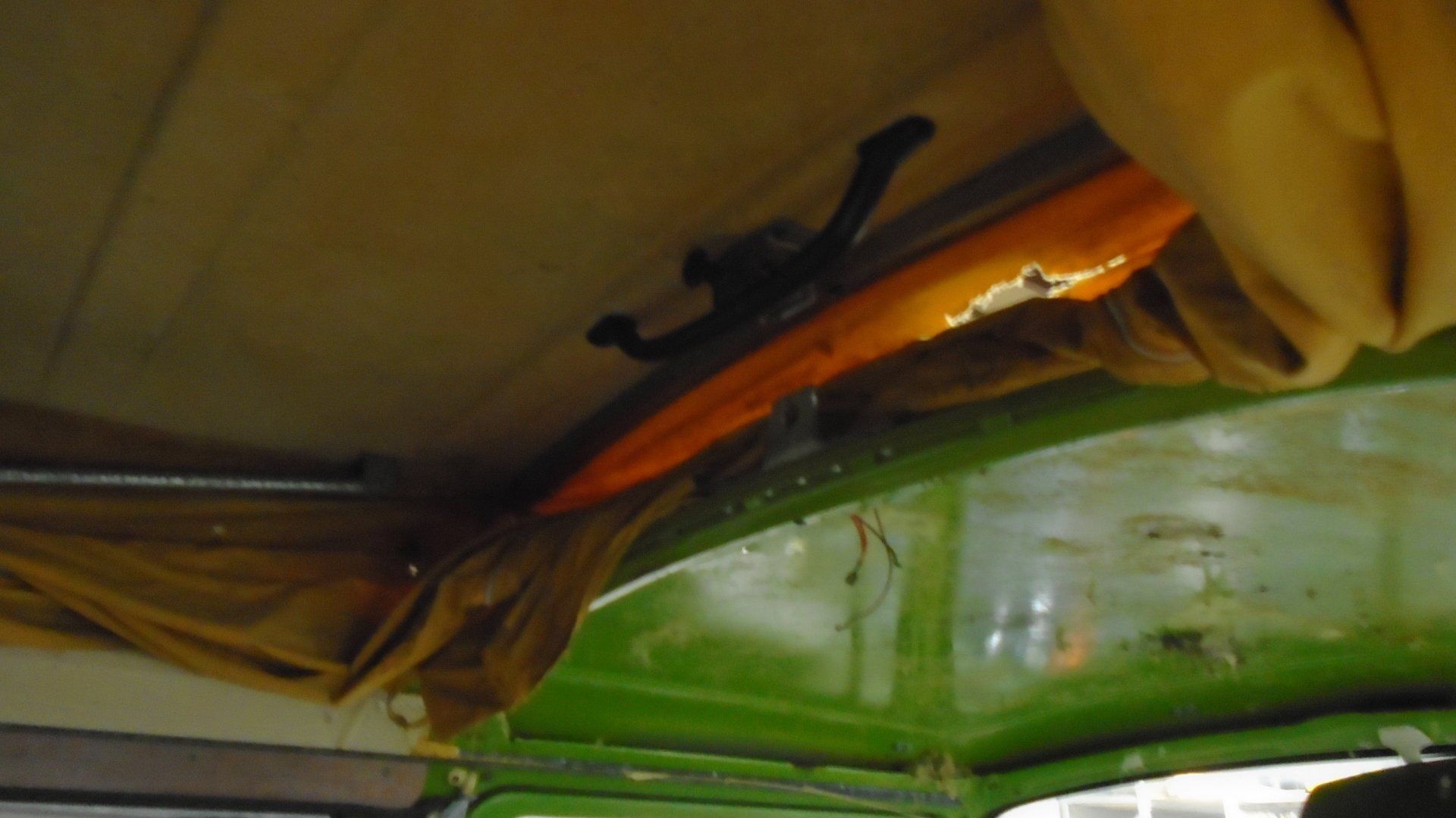 Green van interior, tan fabric detail along ceiling. Black latch visible.
