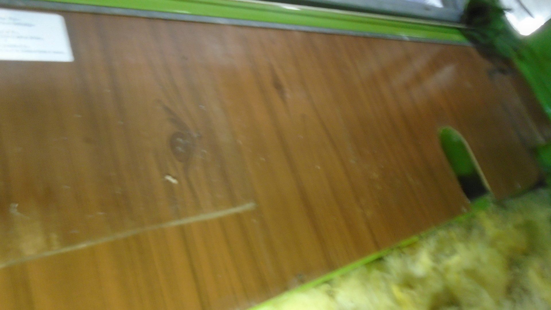 Wooden floor with a greenish frame, a rectangular cutout, and insulation.