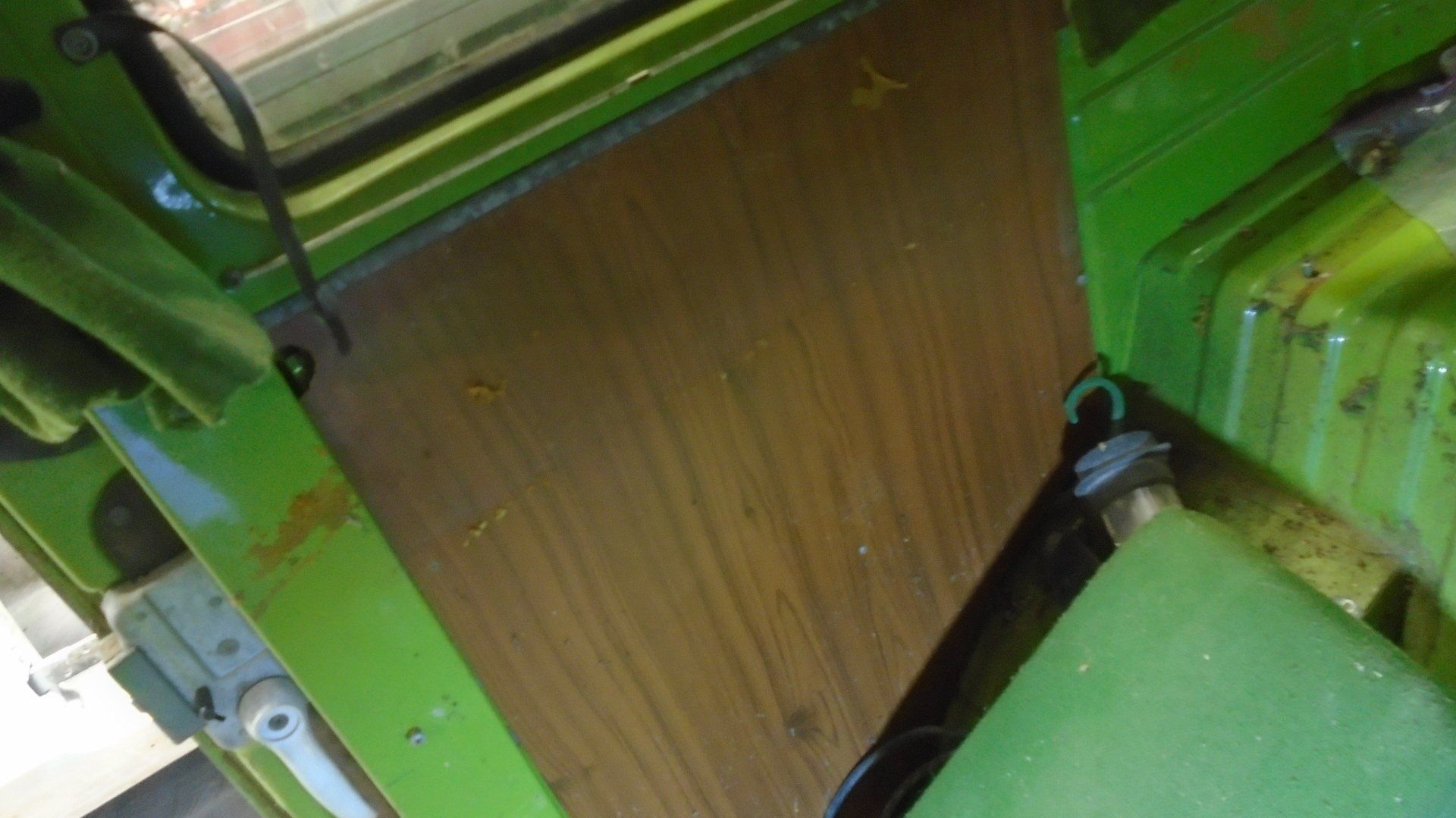 Green interior view, showing a wooden board secured with black loops and metal fixtures.