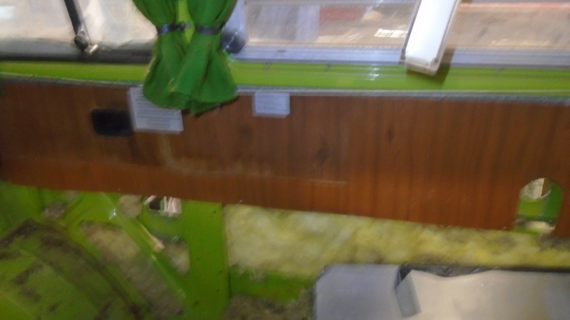 Inside a lime green vintage vehicle, a wooden panel and window are visible.