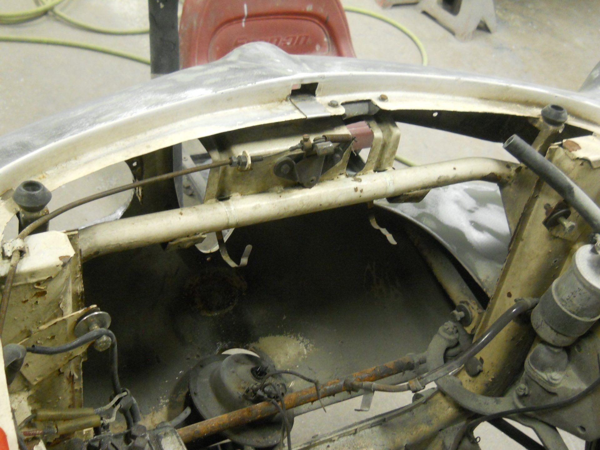 Engine bay of a classic car, showing metal frame and components with beige and dark colors.