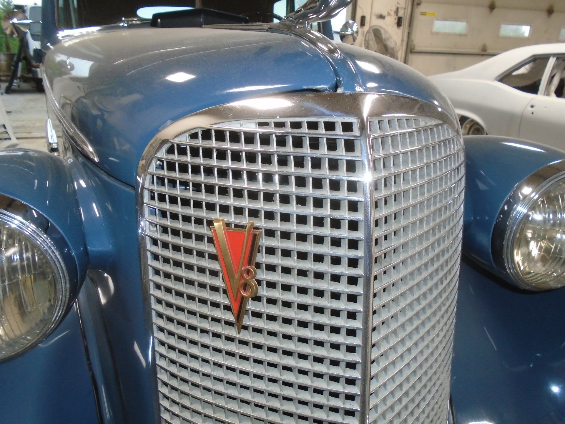 Blue classic car front, chrome grille, red 