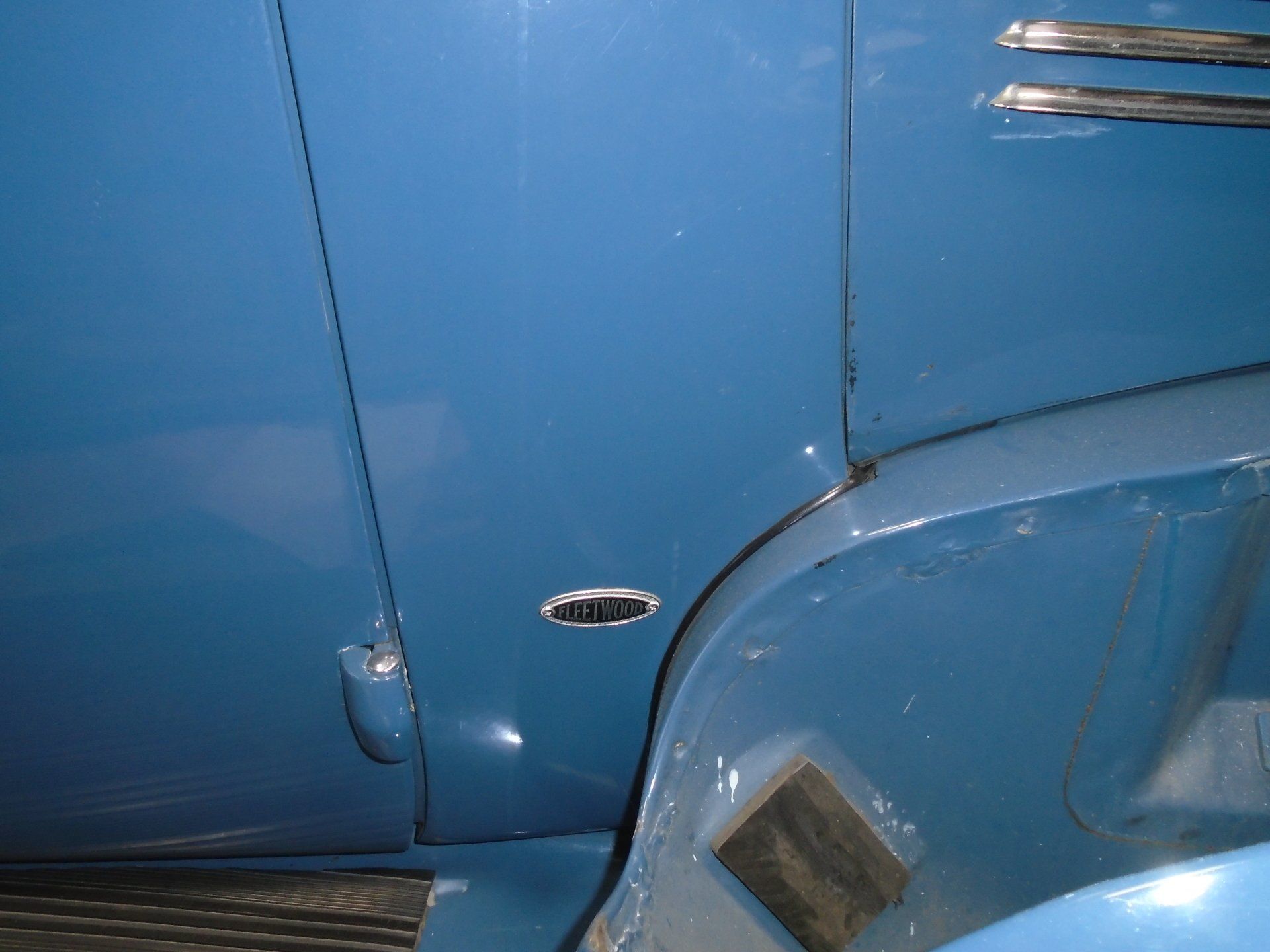 Blue vintage car fender with side marker light.