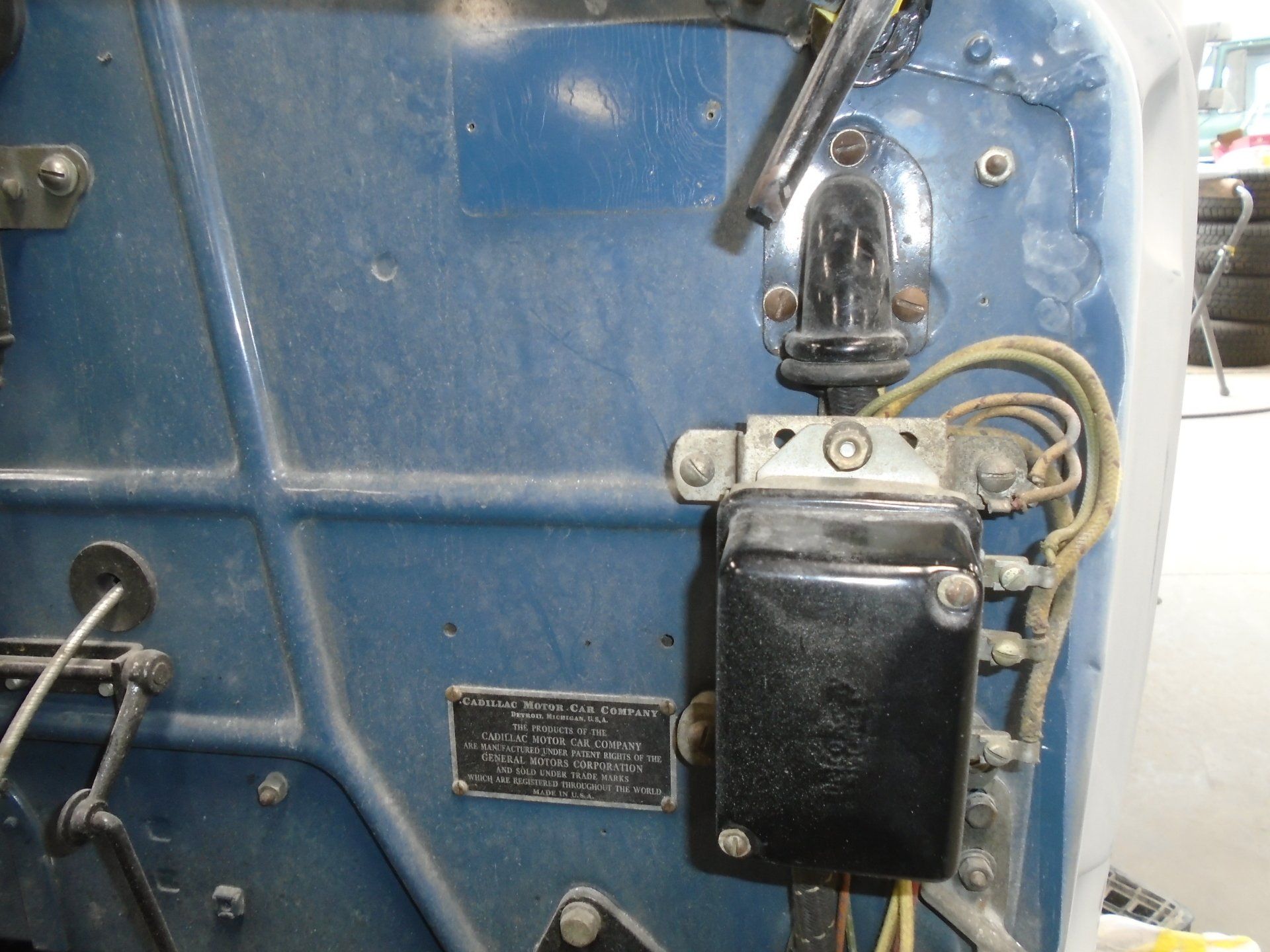 Blue vehicle dashboard with a black electrical component and fuel pump, wiring visible.