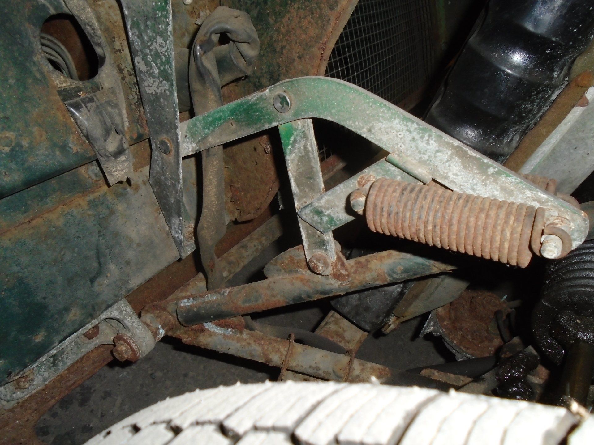 Rusty green metal car hinge and spring.
